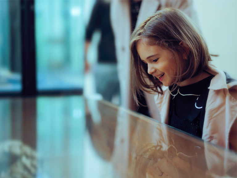 Un enfant devant la vitrine dans un musée
