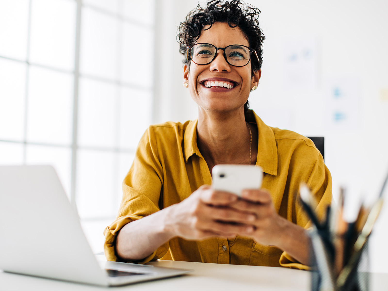 Femme consultant des informations sur un ordinateur portable et un smartphone